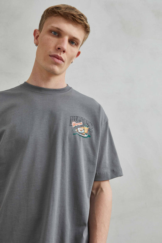 Camiseta oversize unisex gris con diseño gráfico "Desayuno Awesome" en el pecho.
