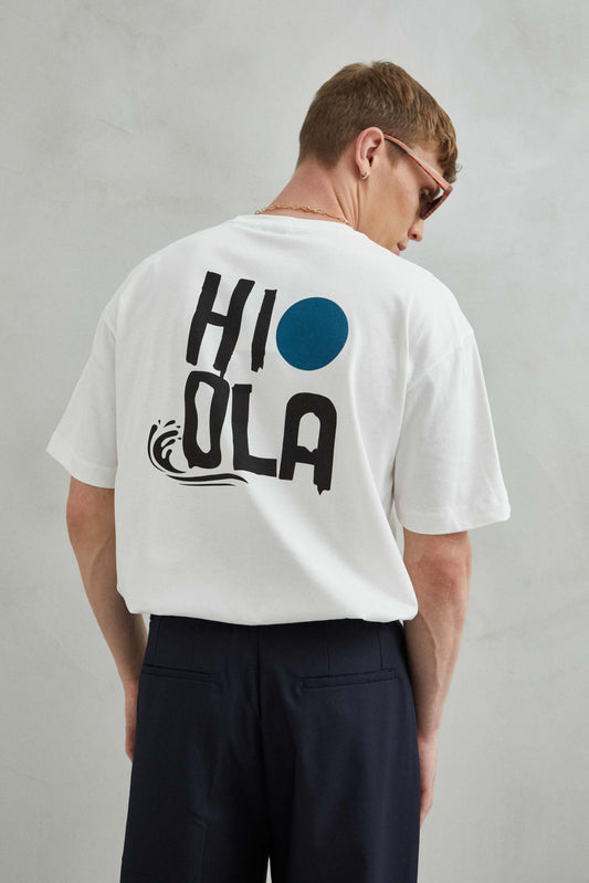 Detalle del diseño HI-OLA-HOLA en camiseta blanca oversize para hombre y mujer