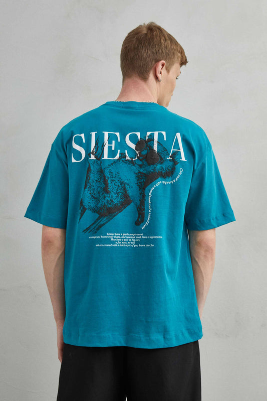 Camiseta verde oversize unisex con diseño de "Siesta" y koala durmiendo en árbol con gafas de sol