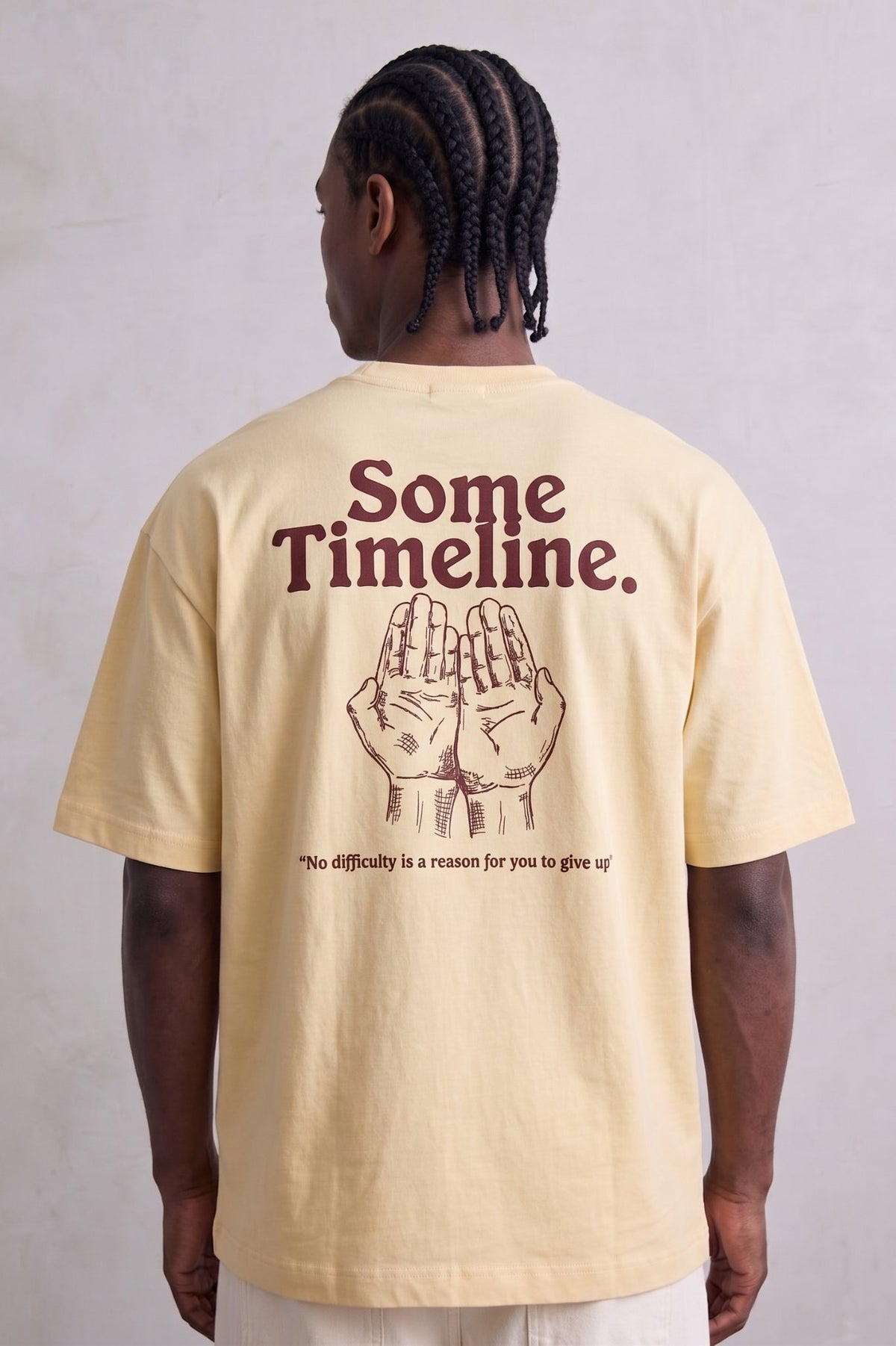 Espalda de camiseta amarilla Some Timeline con manos ilustradas