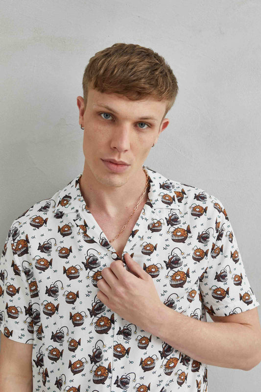 Detalle de camisa hawaiana blanca con diseño de Anglerfish y Pirana, fabricada en 100% viscosa