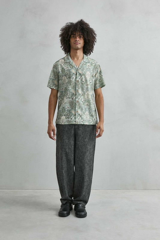 Detalle estampado tropical con ciervos y pavos reales