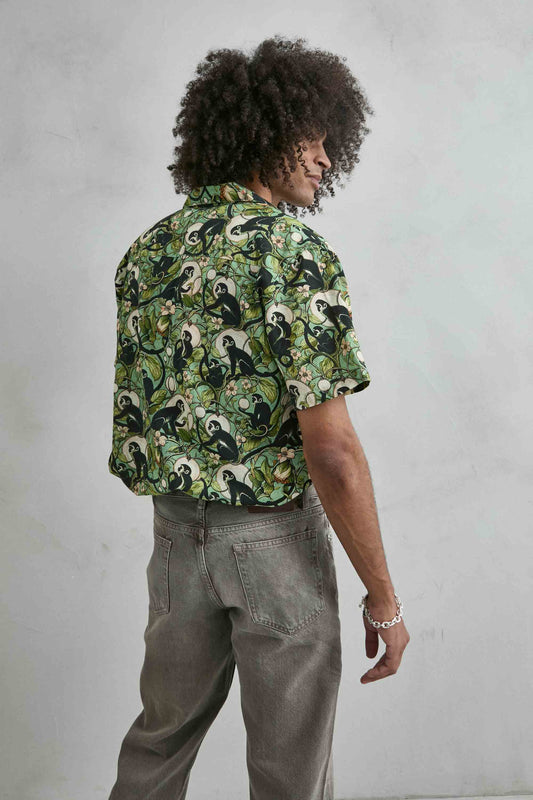 Detalle estampado monos negros sobre árboles camisa hawaiana