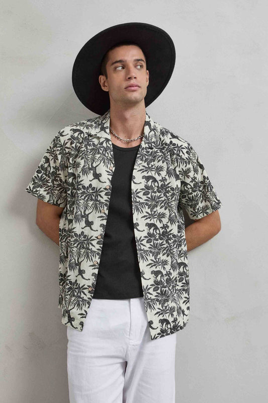 Camisa de hombre color crudo con estampado negro de monos y hojas tropicales, vista frontal.