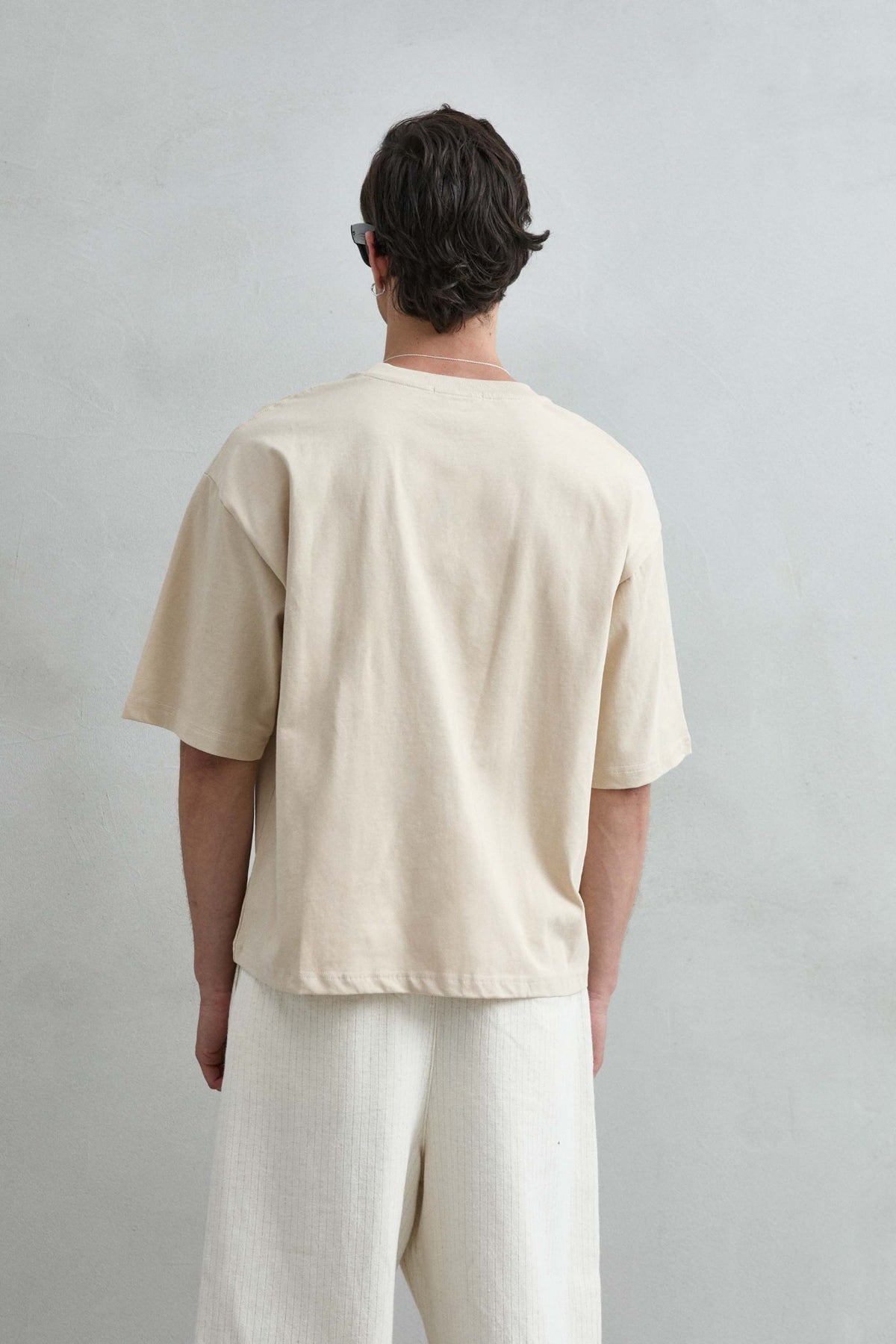 Camiseta cropped oversize beige lisa de hombre, vista posterior lisa.