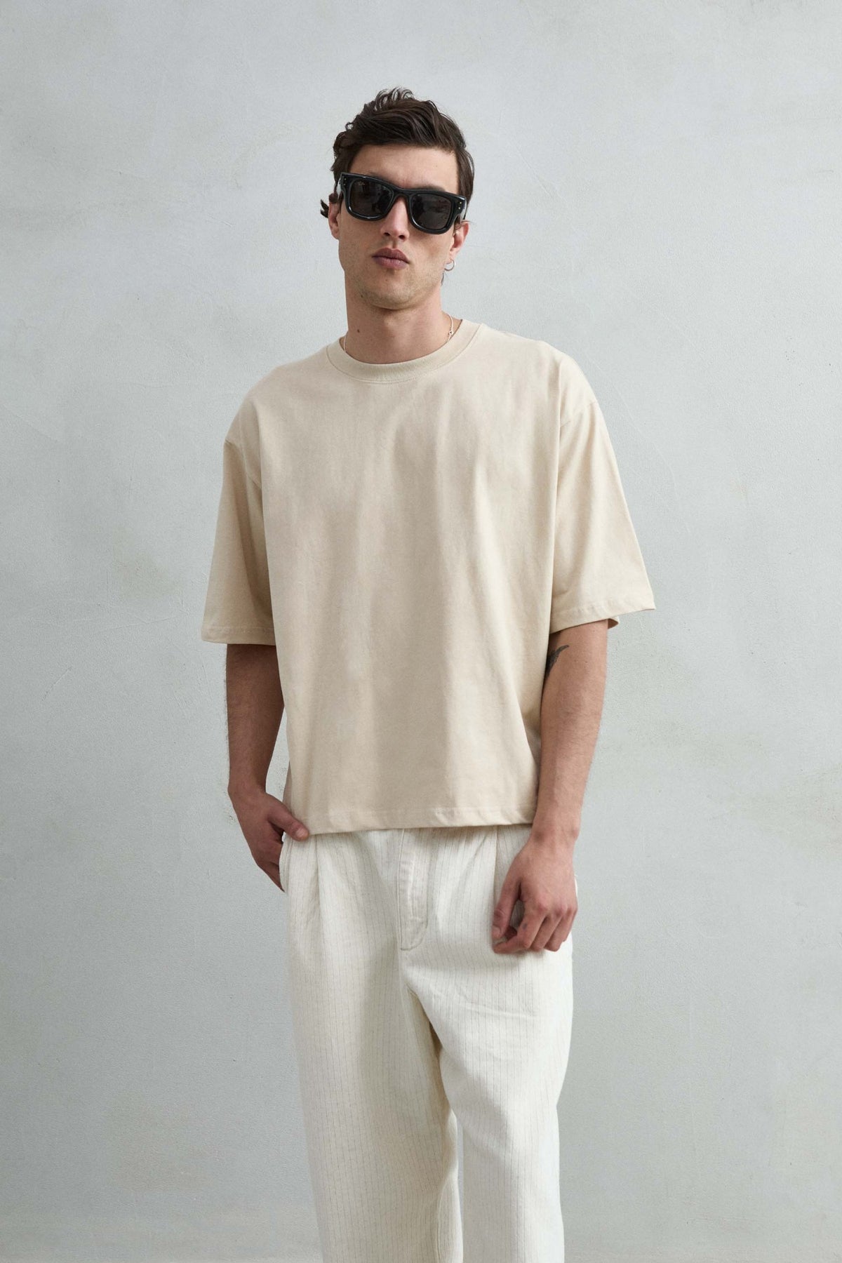 Camiseta cropped oversize beige lisa de hombre, vista frontal.