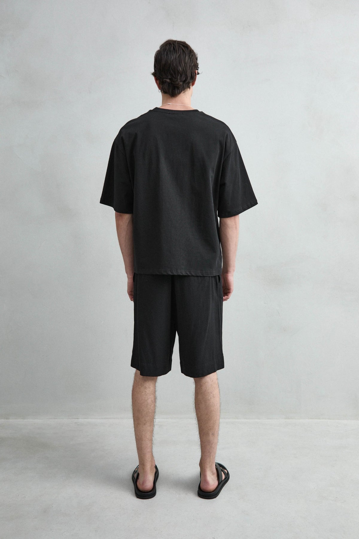 Camiseta cropped oversize negra lisa de hombre, vista posterior lisa.