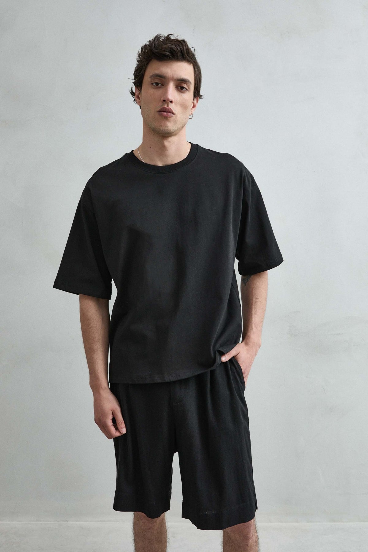 Camiseta cropped oversize negra lisa de hombre, vista frontal.