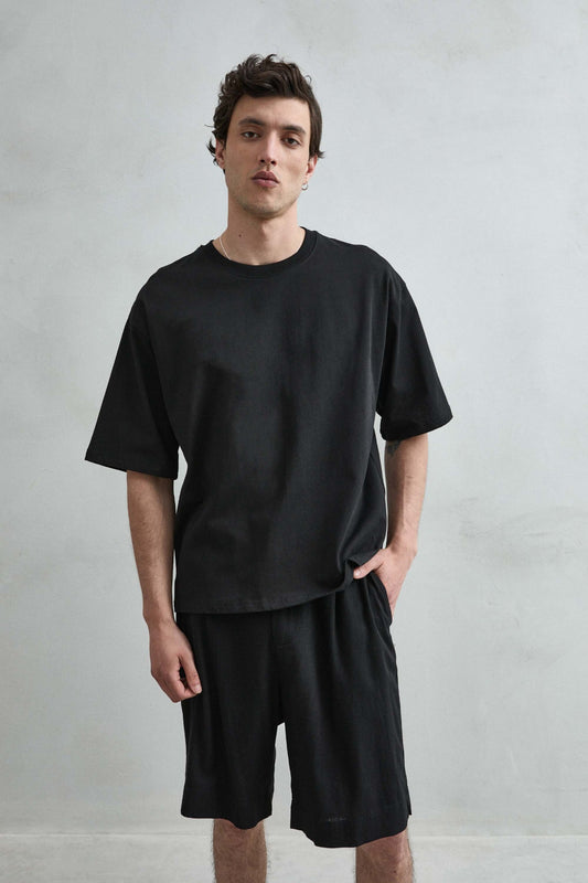 Camiseta cropped oversize negra lisa de hombre, vista frontal.