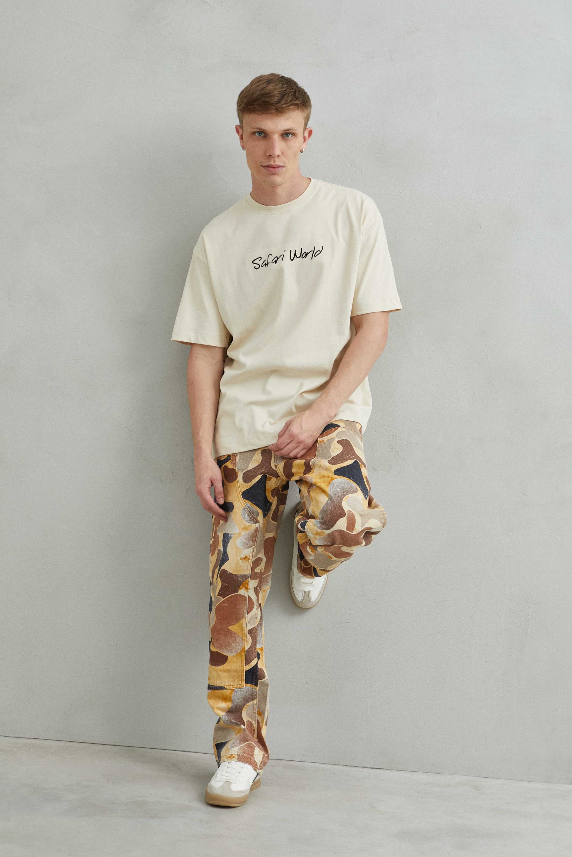 Modelo usando camiseta Safari World con jirafa, estilo relajado y natural