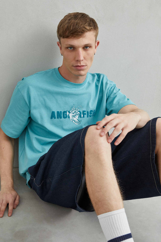 Camiseta oversize unisex blanca con ilustración de pez abisal y piraña en el pecho