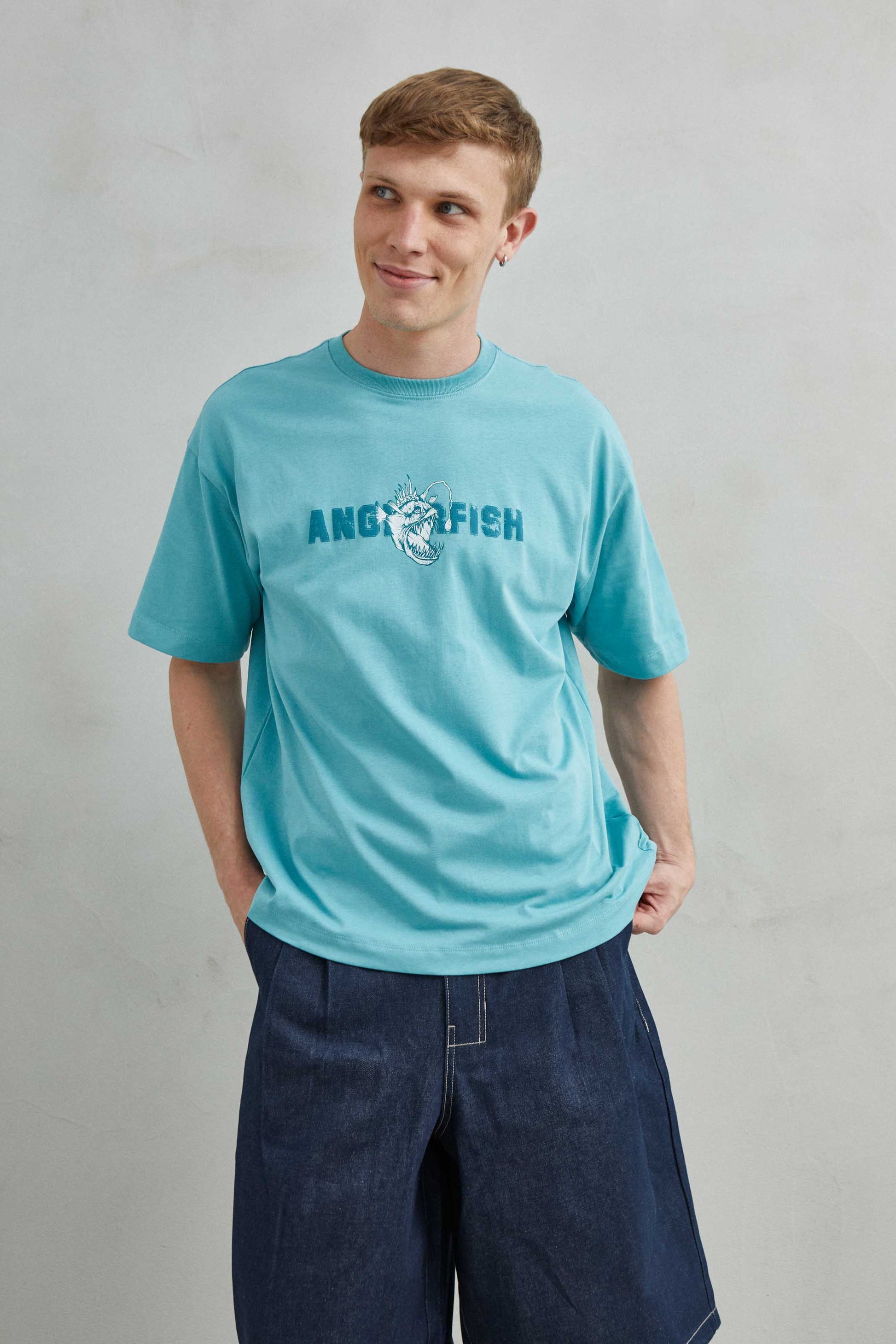 Camiseta oversize unisex doblada, muestra textura de algodón suave y diseño artístico