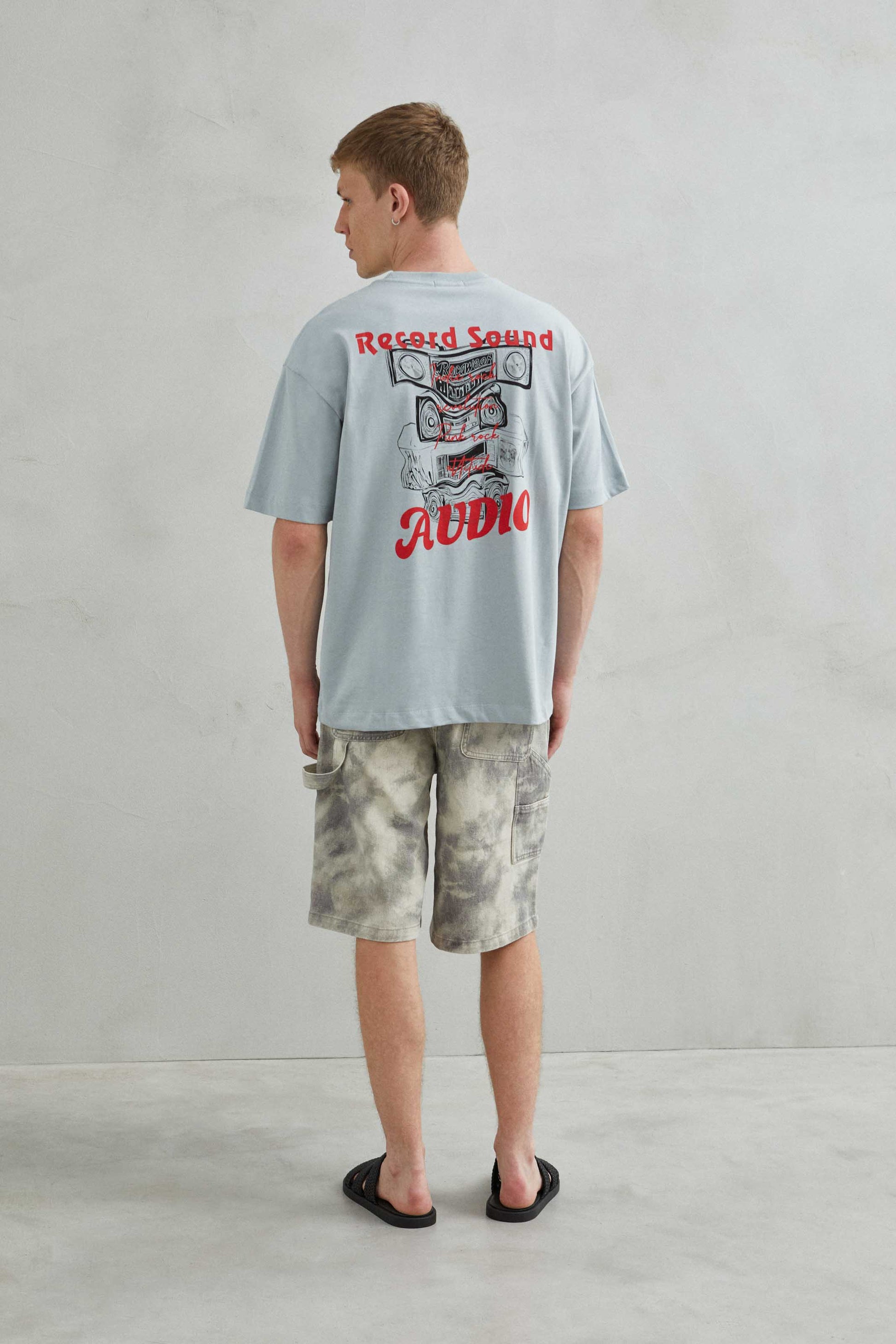 Parte trasera de camiseta oversize gris sin estampado.