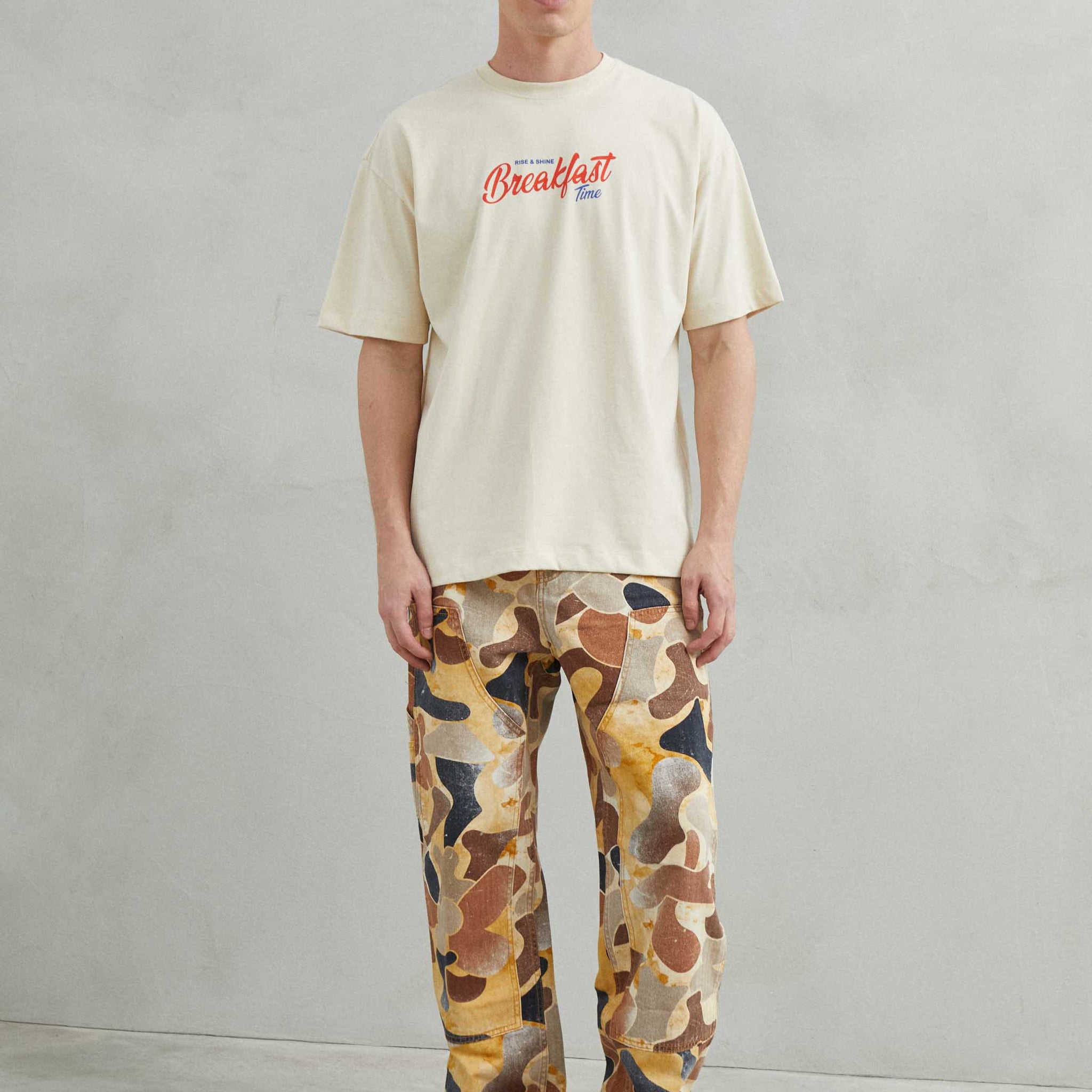  Primer plano del diseño "Breakfast y Croissant" en la camiseta beige.