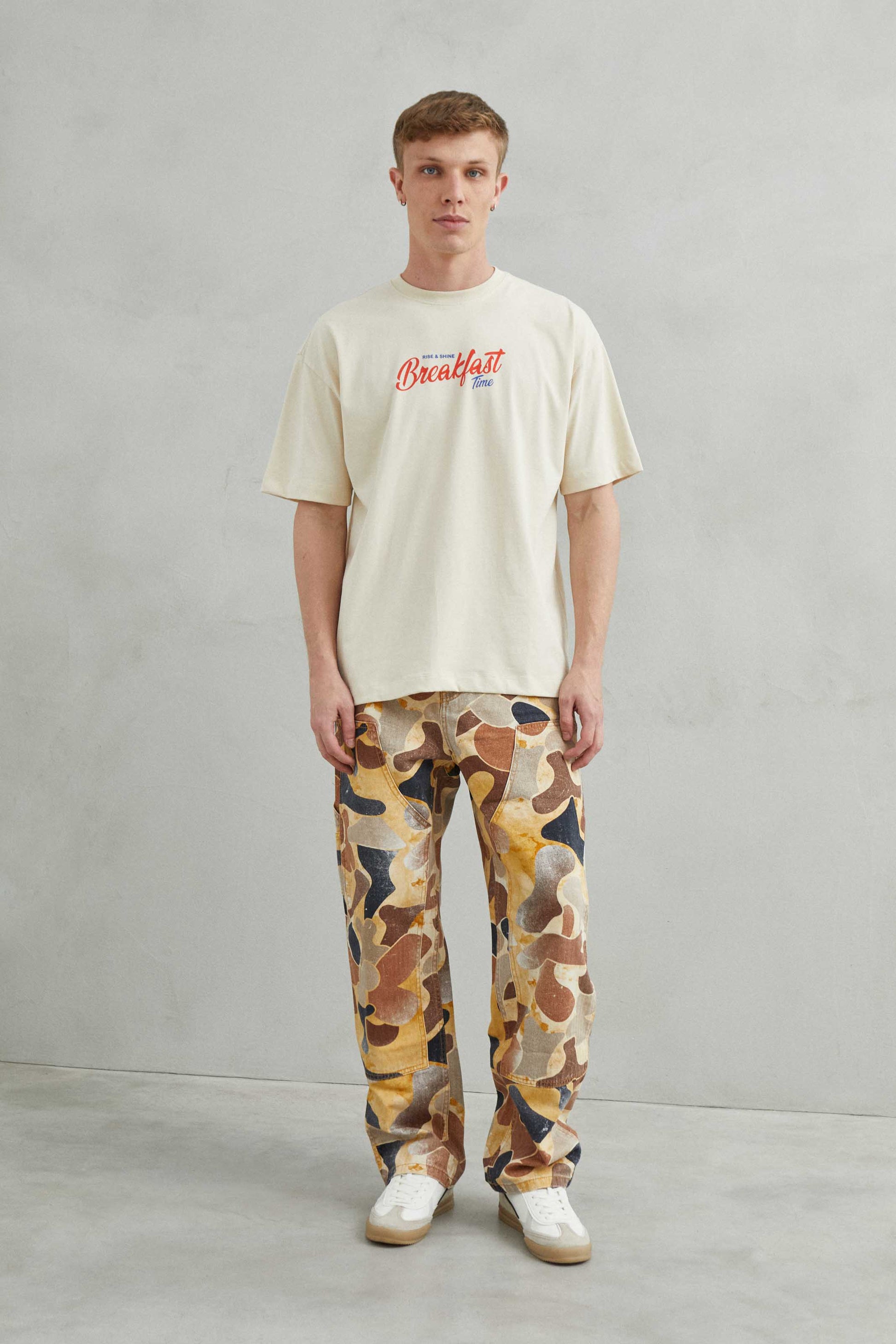  Primer plano del diseño "Breakfast y Croissant" en la camiseta beige.