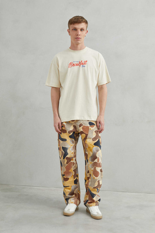  Primer plano del diseño "Breakfast y Croissant" en la camiseta beige.