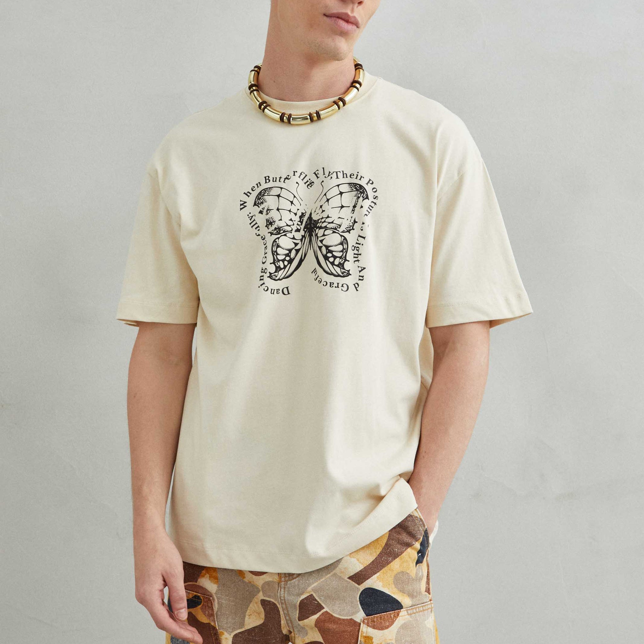 Camiseta oversize unisex beige con diseño de mariposa en el pecho