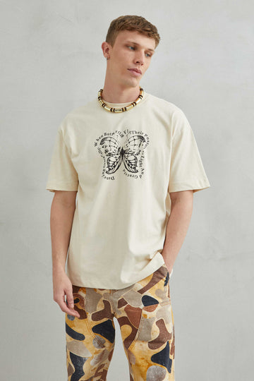 Camiseta oversize unisex beige con diseño de mariposa en el pecho