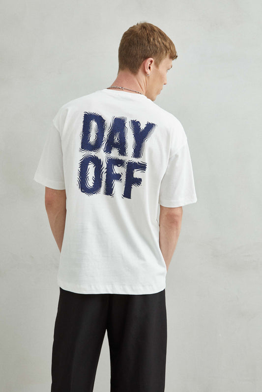 Parte trasera de camiseta blanca de corte oversize, con diseño day off.