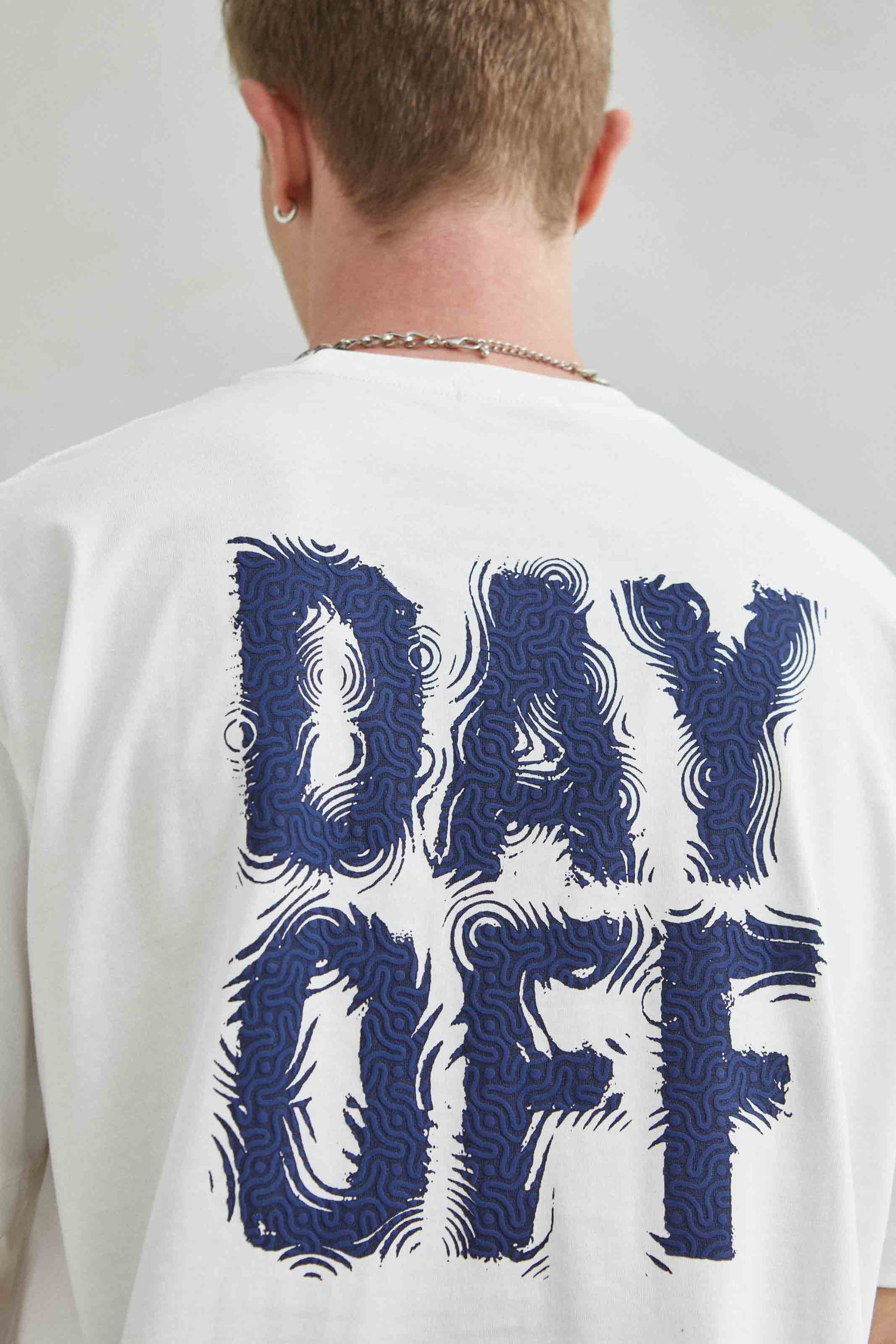 Modelo vistiendo la camiseta blanca “Day Off” con estilo casual urbano.