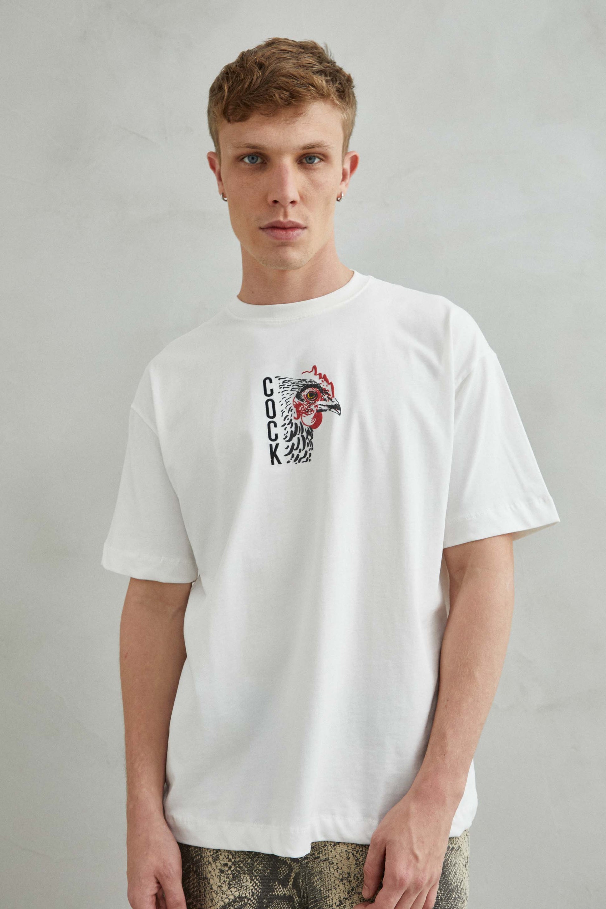 camiseta blanca oversize con estampado de gallo y texto COCK, vista frontal