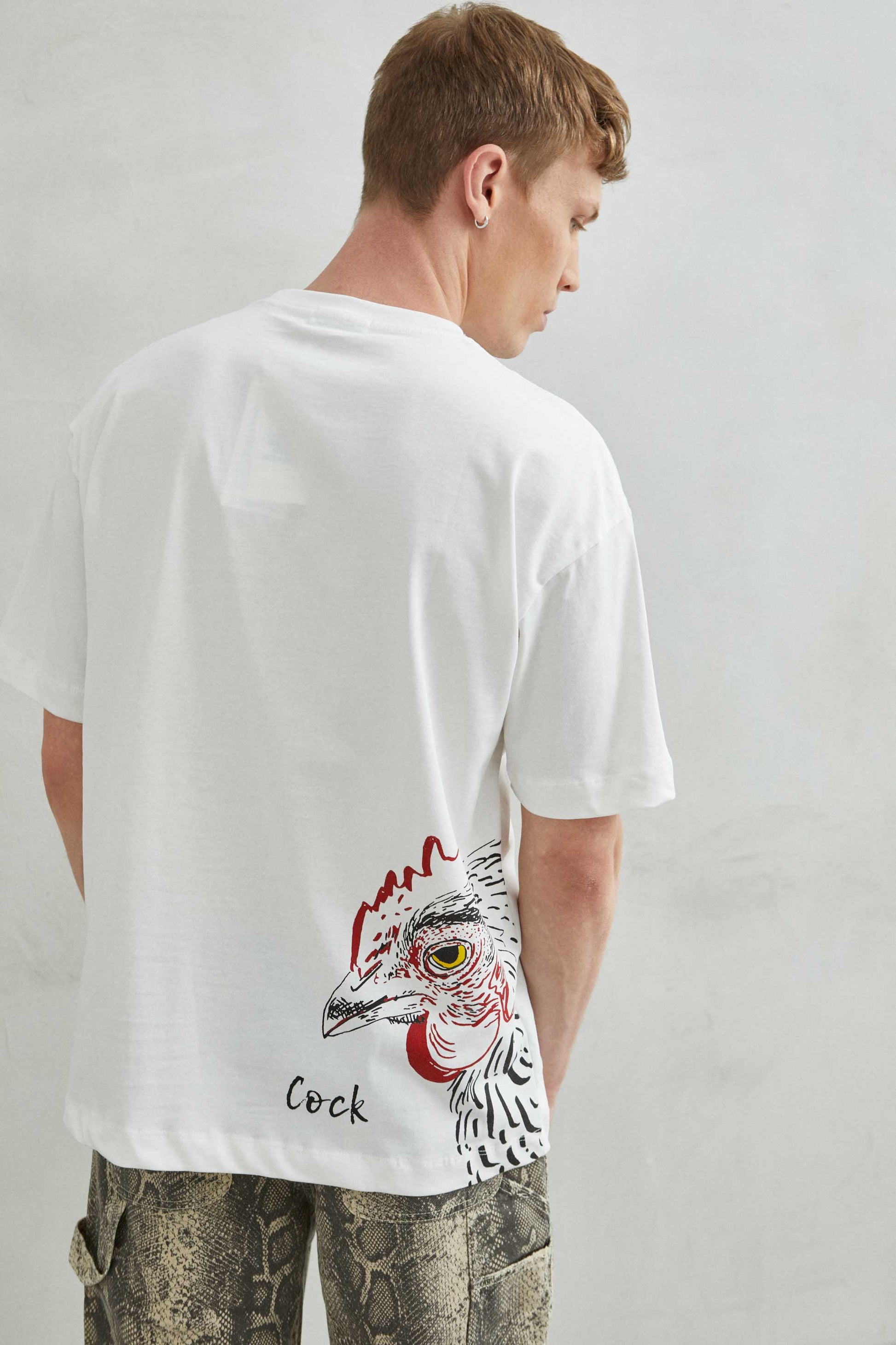 camiseta oversize blanca con ilustración de gallo y palabra COCK, vista trasera 