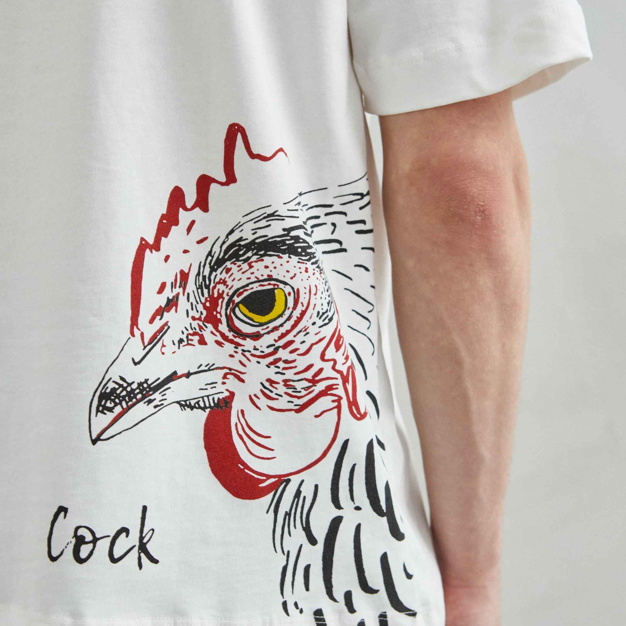 detalle del estampado COCK en camiseta blanca oversize, primer plano del pecho