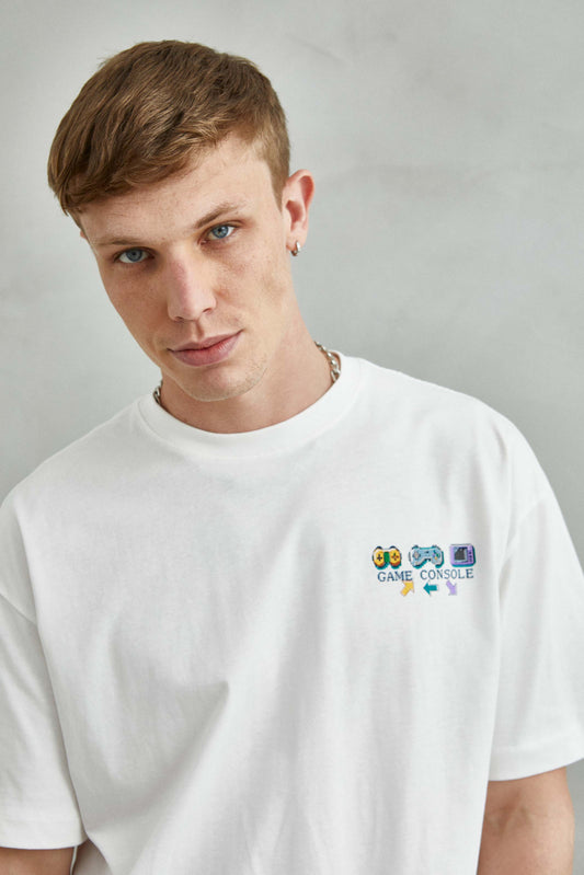 camiseta de algodón blanca con diseño colorido de controles de videojuegos retro