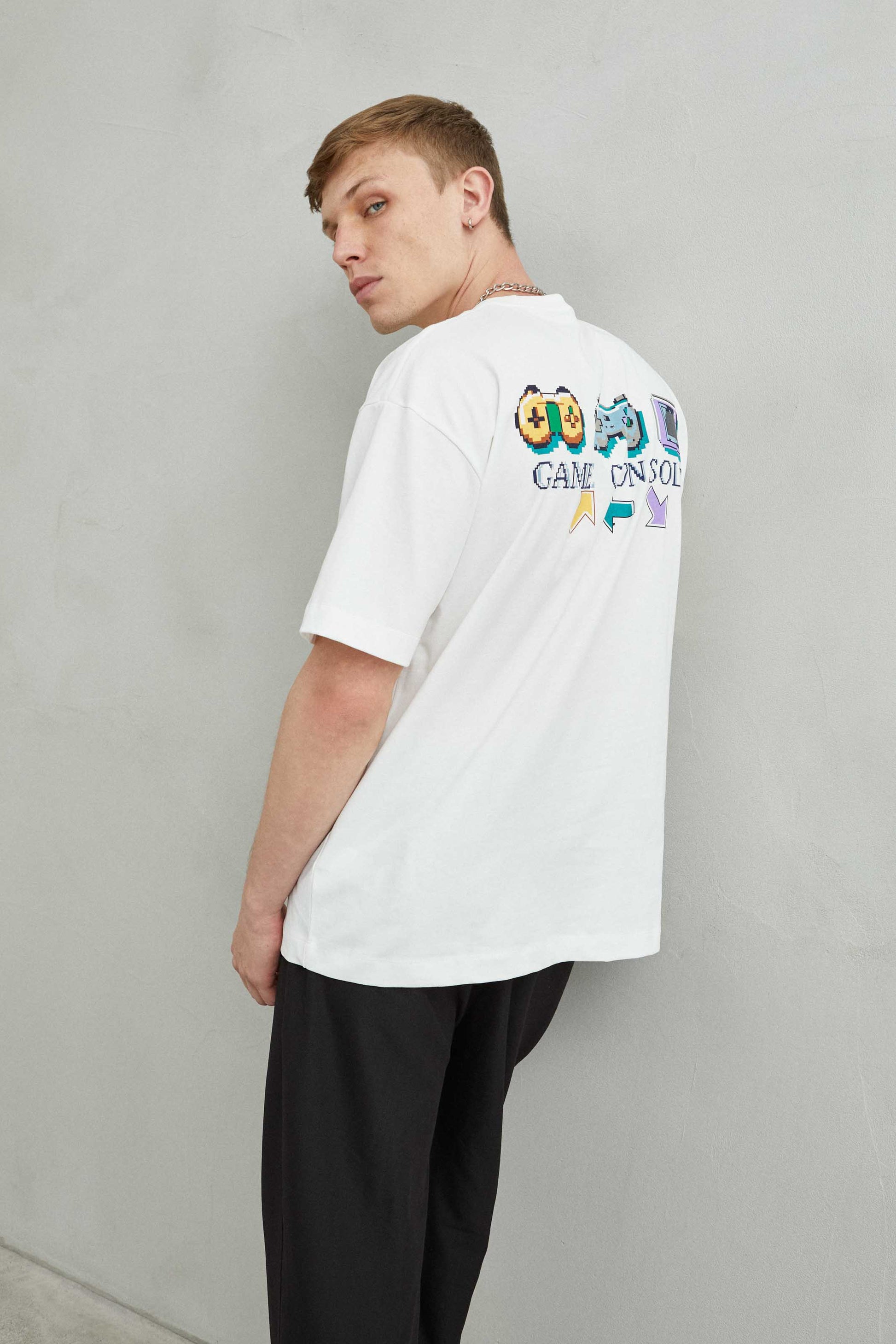 detalle del gráfico con varios joysticks en camiseta blanca oversize de estilo gamer