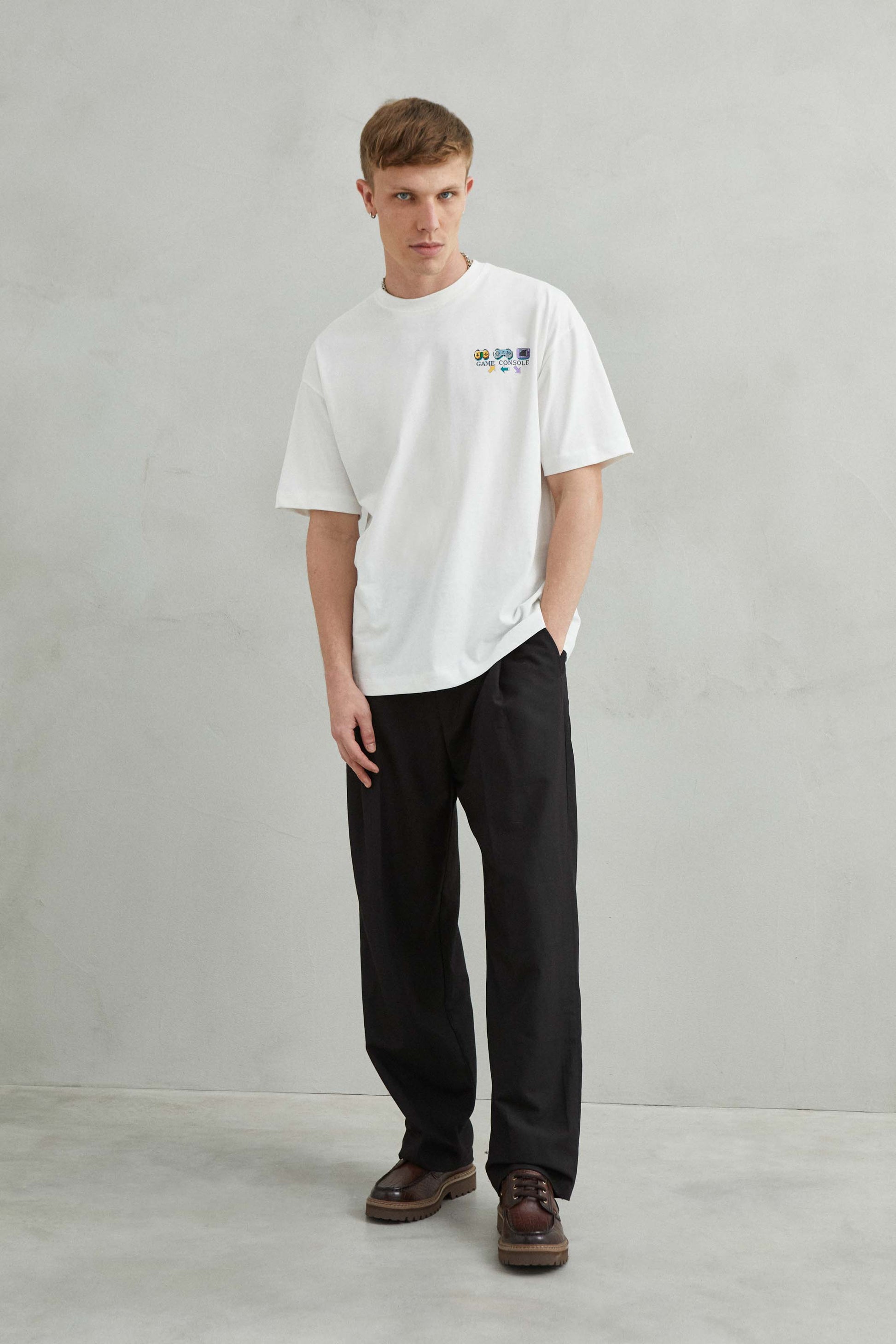 modelo con camiseta blanca y mandos de consola estampados en estilo divertido y juvenil