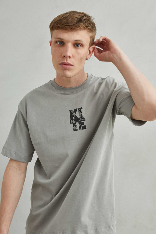 Modelo con camiseta gris oversize unisex estilo skate urbano casual