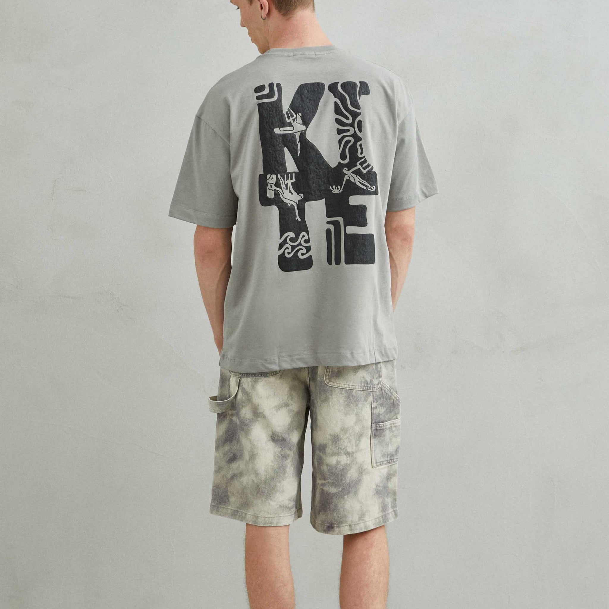 Camiseta gris oversize unisex con diseño kite y patinete estilo skate trasera