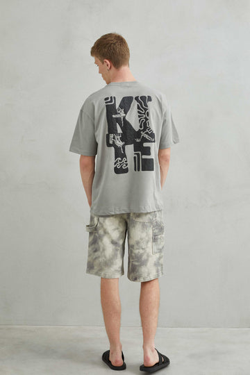 Camiseta gris oversize unisex con diseño kite y patinete estilo skate trasera