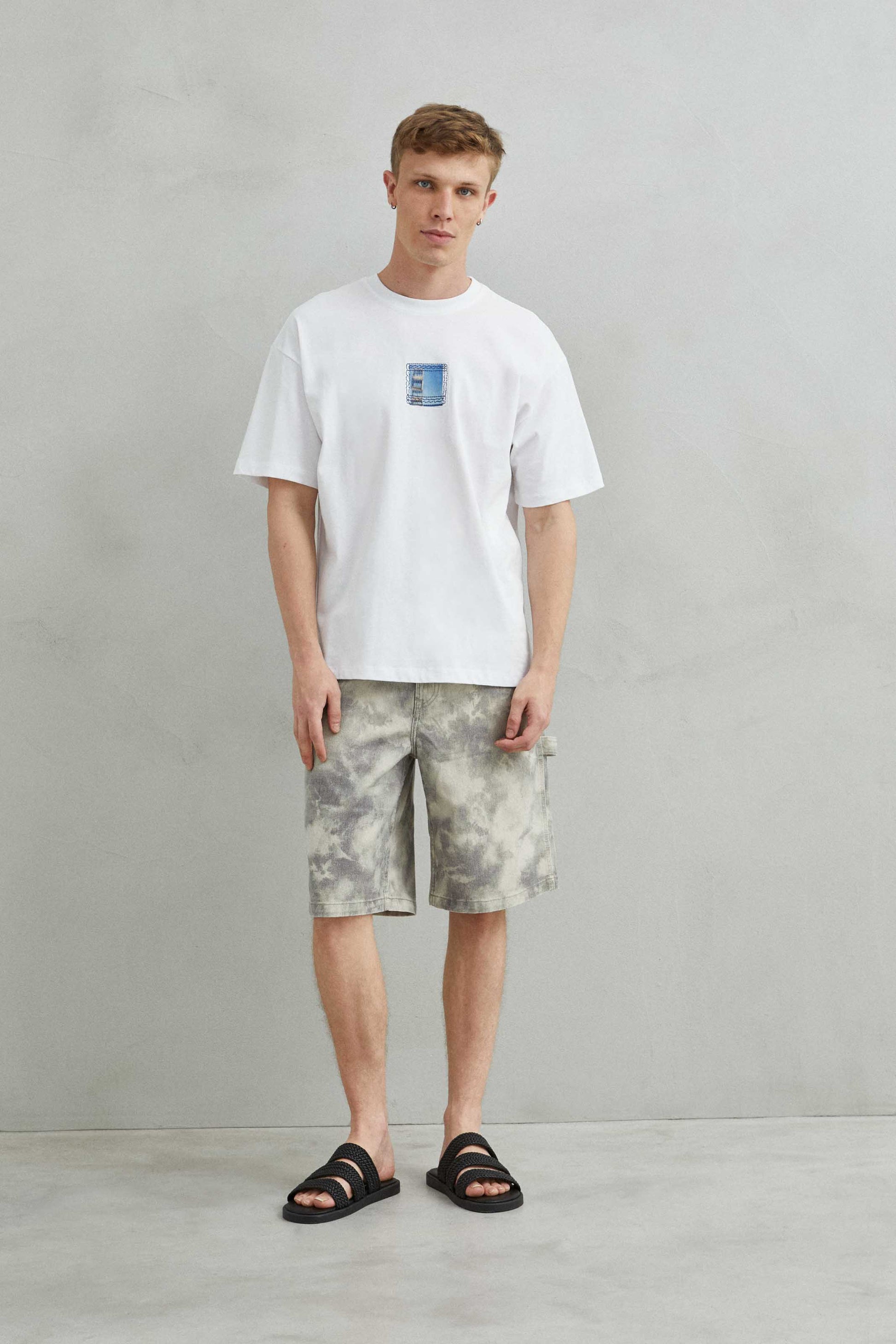 Modelo con camiseta blanca oversize unisex, estilo catalán y arquitectura de Barcelona