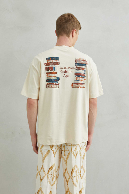 Detalle de la camiseta beige oversize con diseño literario TURN THE PAGE, FASHION AGE