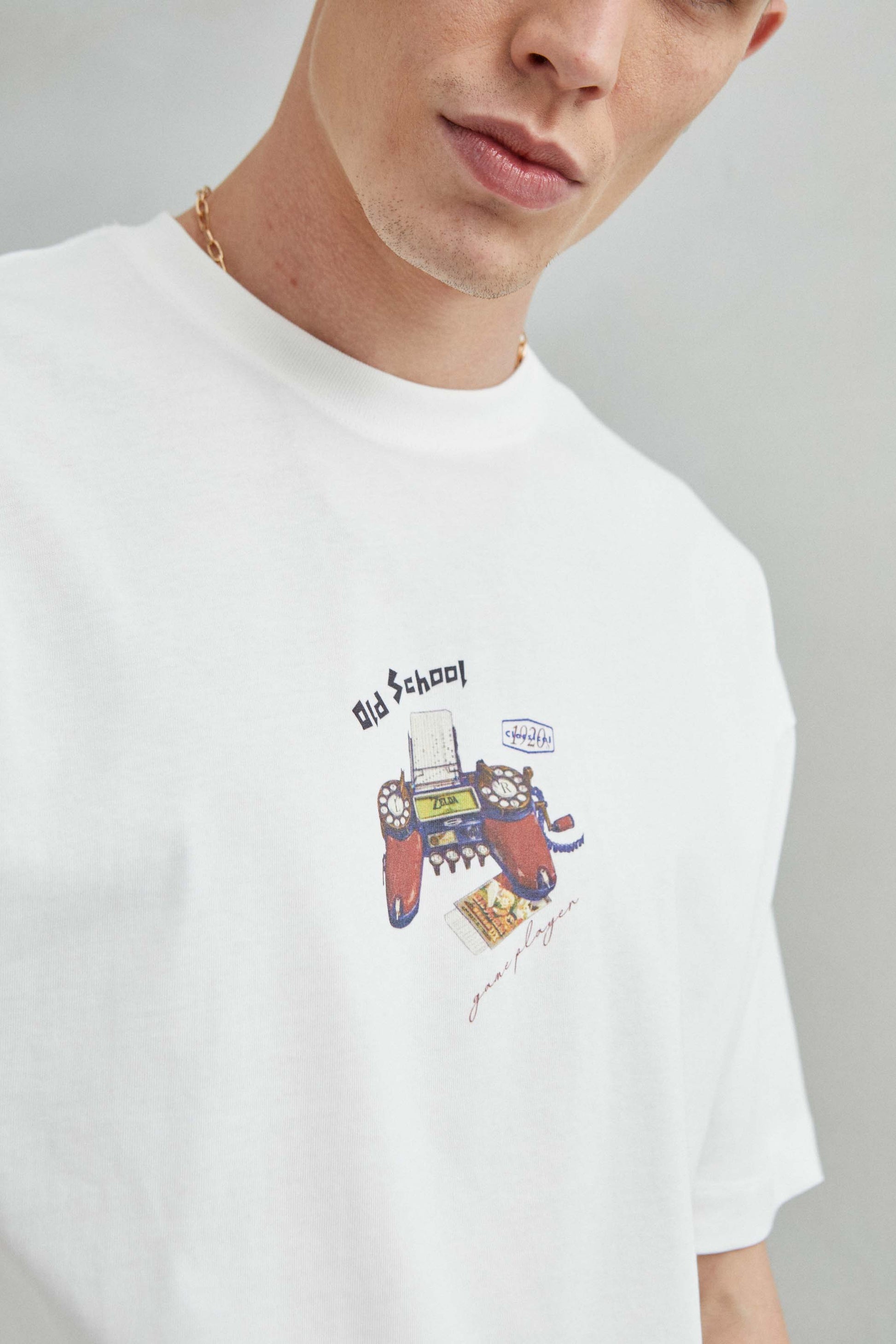 Detalle de la consola retro en la camiseta blanca oversize unisex, estilo Old School, 100% algodón.