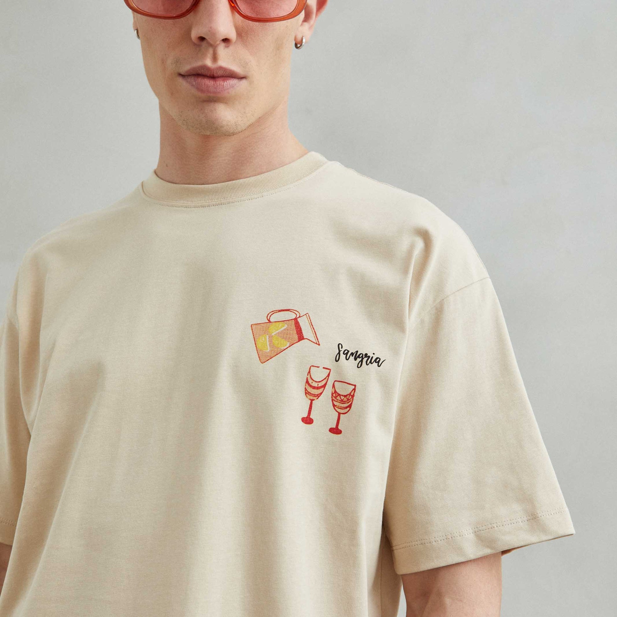 Camiseta beige oversize unisex con diseño de platos españoles como Sangría, Paella, Jamón y Churros con chocolate.