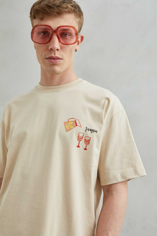 Camiseta beige oversize unisex con diseño de platos españoles como Sangría, Paella, Jamón y Churros con chocolate.
