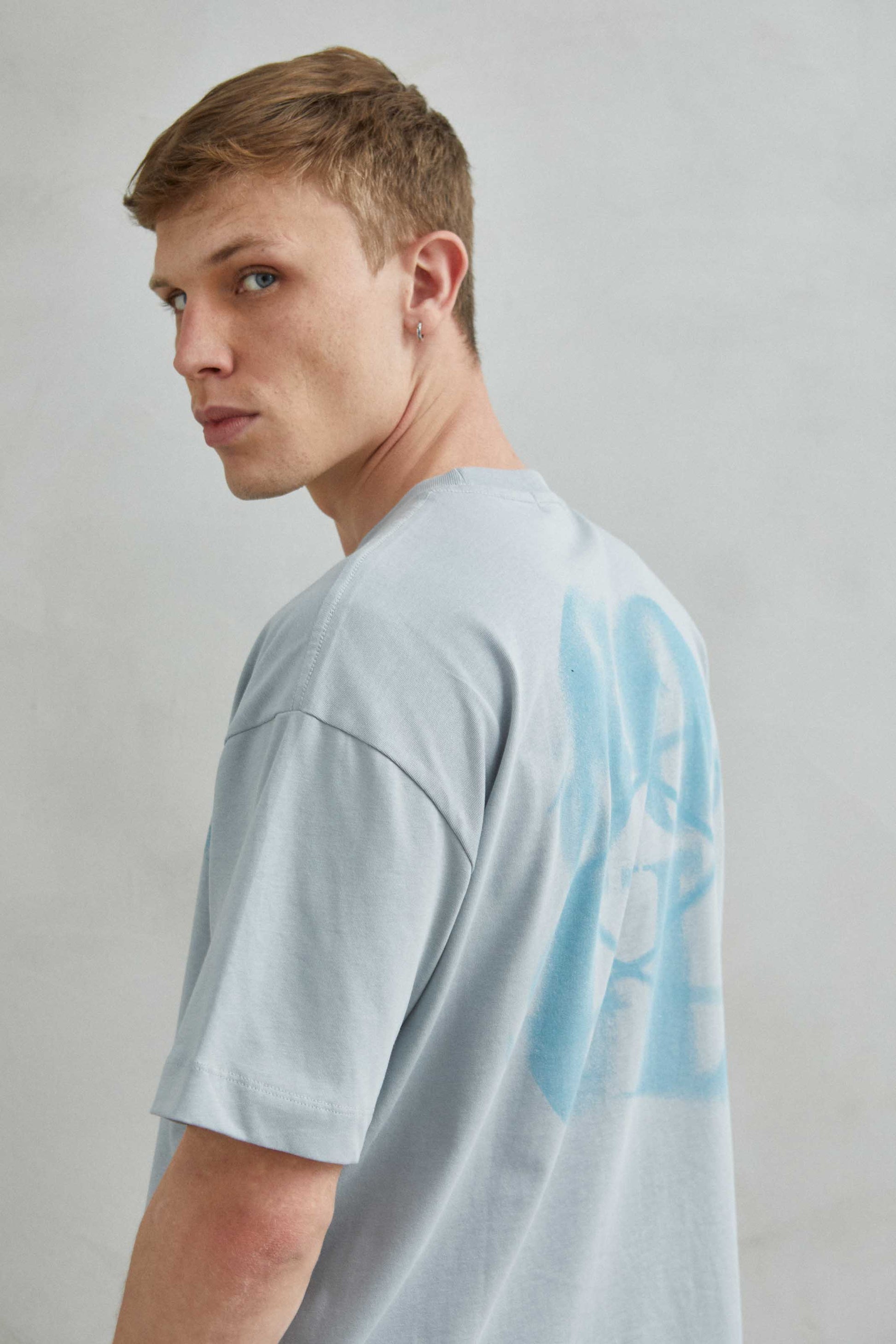  Detalle de camiseta gris oversize con efecto de arena y diseño "SOUL" en impresión sutil