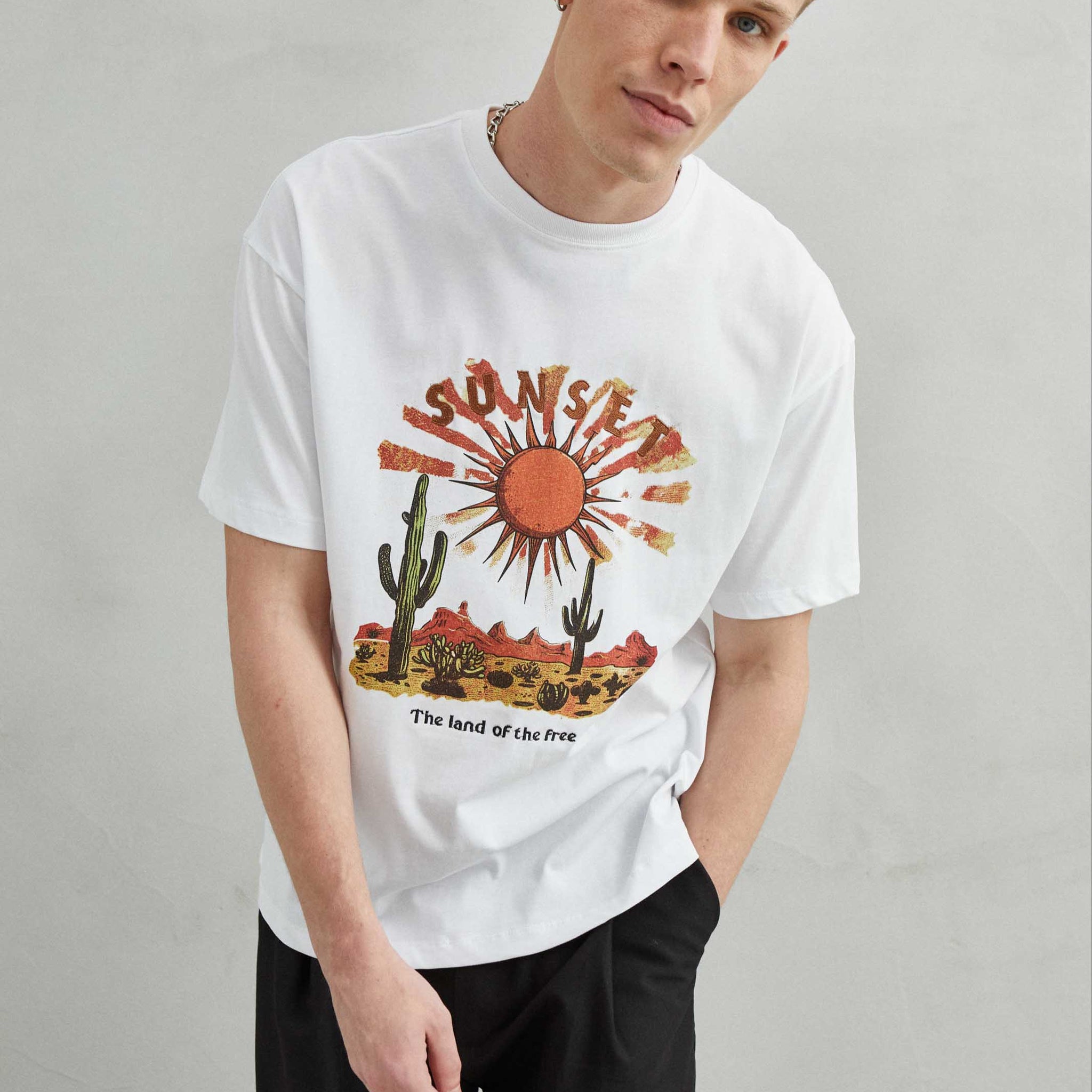 Camiseta blanca oversize unisex con bordado "SUNSET", sol y cactus en el desierto