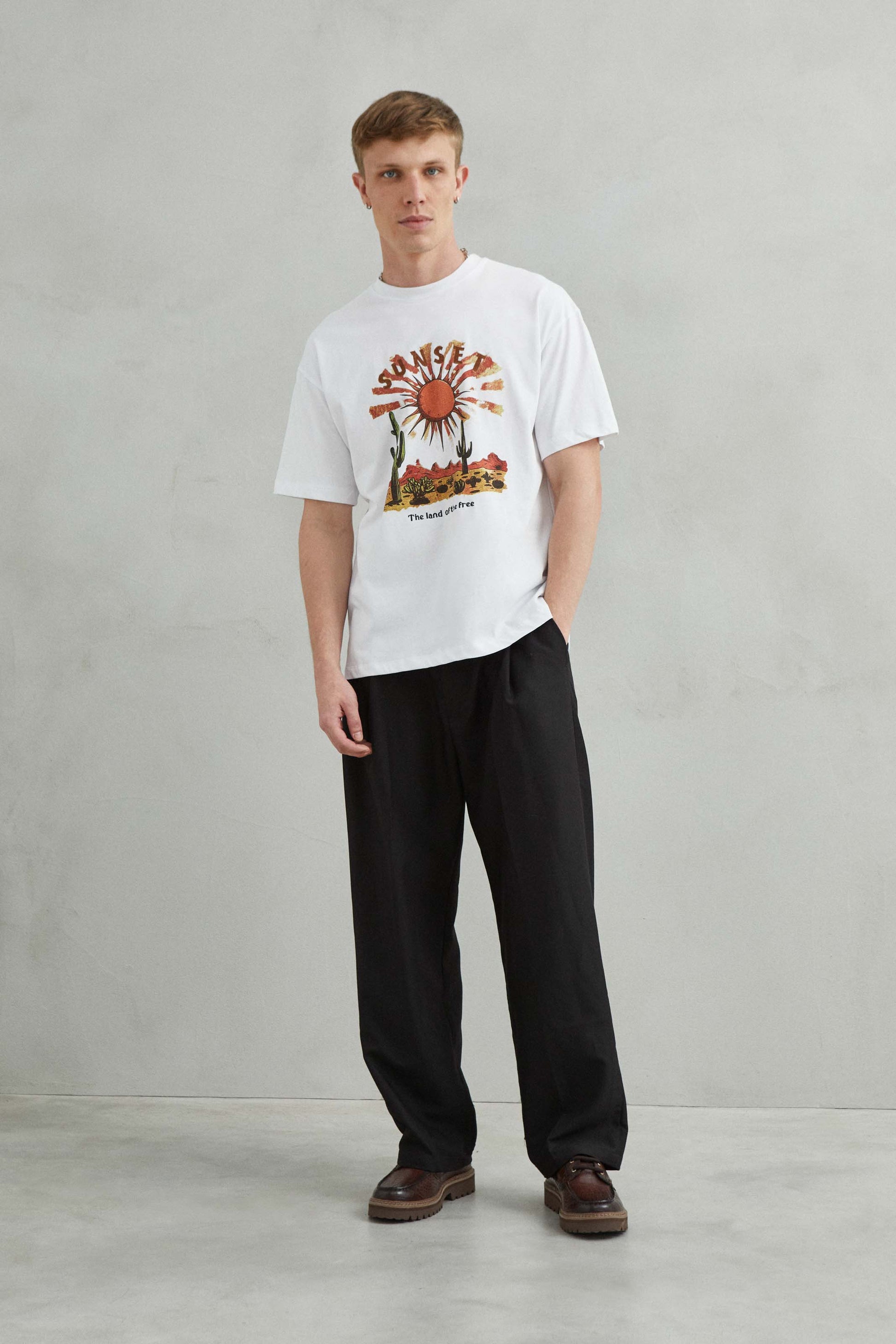 Camiseta 100% algodón con diseño de "SUNSET", sol y cactus en un paisaje desértico
