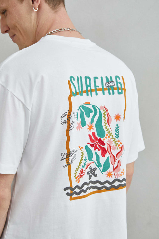  Detalle de camiseta blanca oversize con diseño de mar con algas y flores rojas bordadas