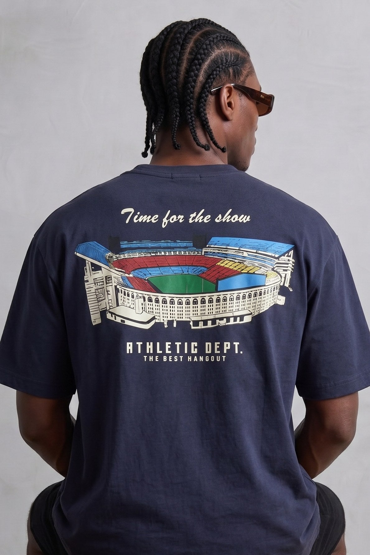 Espalda de camiseta azul marino con estadio multicolor y texto Time for the Show y Athletic Dept.