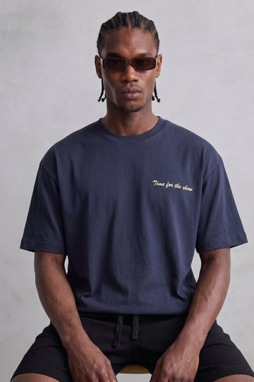 Camiseta oversize azul marino Time for the Show con pequeño texto claro en el pecho, vista frontal.