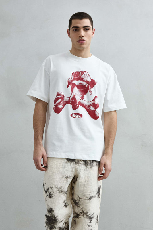 Vista frontal de medio cuerpo de la camiseta oversize blanca Doggy para hombre, con perro de gafas y gorra, hueso y estampado burdeos.