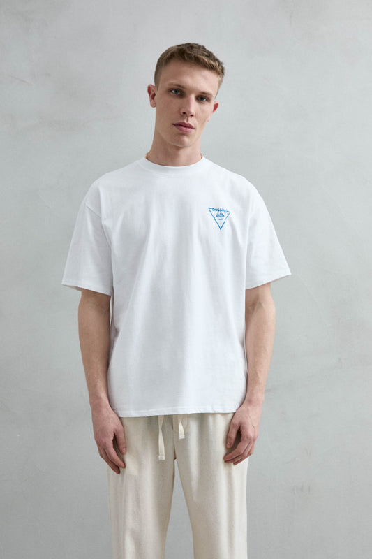 Camiseta oversize blanca Leisure Time con pequeño motivo triangular azul en el pecho, vista frontal.