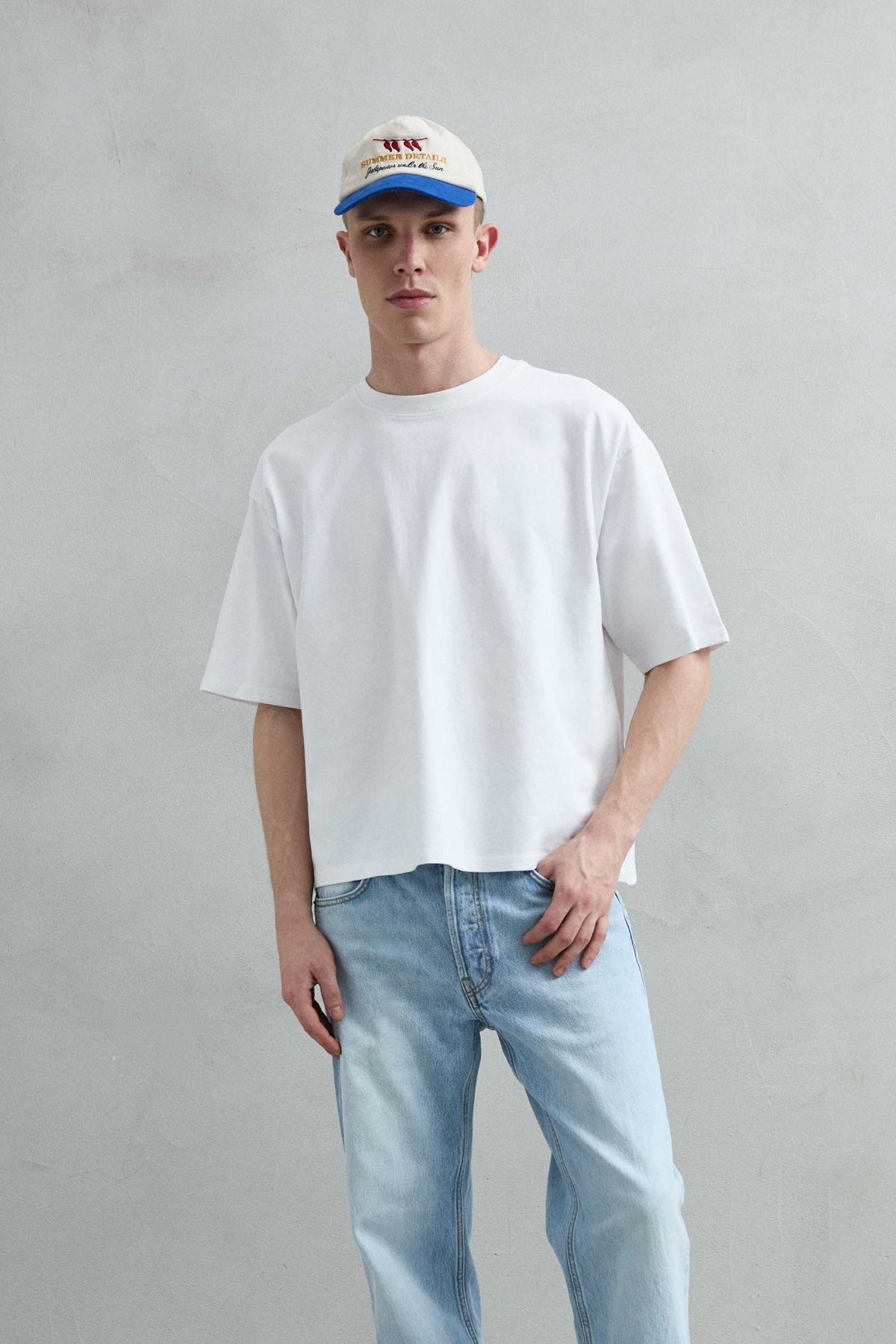 Camiseta oversize blanca lisa de hombre, vista frontal de medio cuerpo.