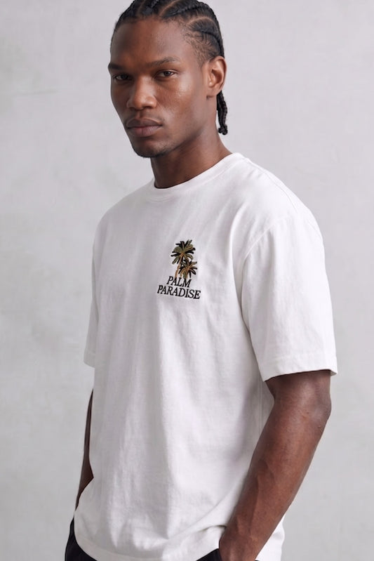 Camiseta oversize blanca Palm Paradise con pequeño estampado de palmeras en el pecho, vista frontal.