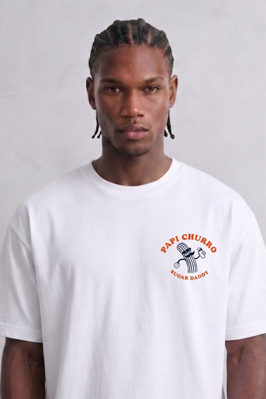 Camiseta oversize blanca Papi Churro con pequeño dibujo de churro y letras naranjas en el pecho, vista frontal.