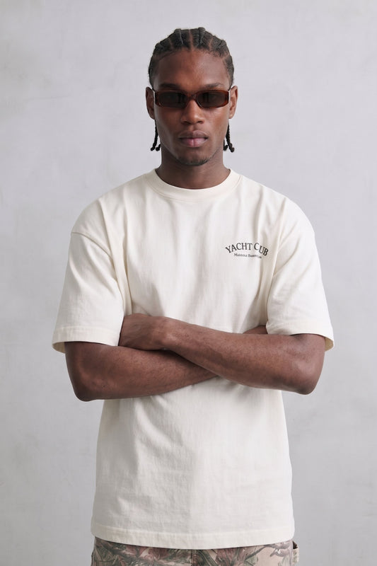 Camiseta oversize color crema Yacht Club con pequeño texto negro en el pecho, vista frontal.